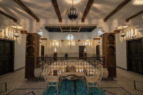 梅尔祖卡Riad Jouba的一间带桌椅和吊灯的用餐室