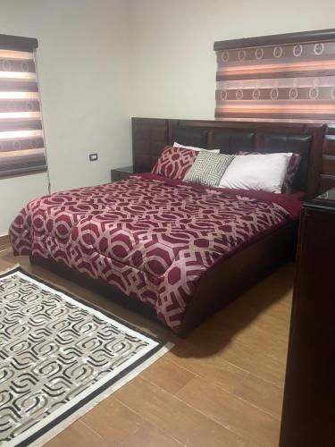 Ad Dimnahمزرعة النجم Najem farm的一间卧室配有一张大床和木制床头板