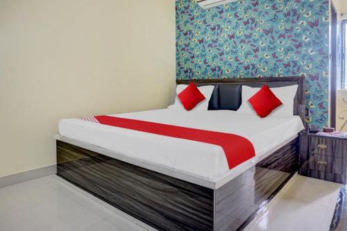 巴特那Flagship Sk Brother Hotel的一间卧室配有红色枕头的床