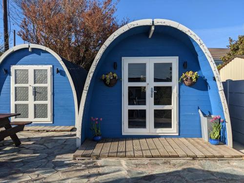 卡斯尔敦贝尔A house and a half on Beara peninsula的蓝色的房子,设有白色门和木门廊
