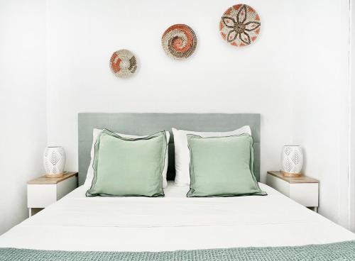 桑帕克Apartamento Atardecer en Menorca Son Parc Vista al campo de golf的卧室配有带绿色枕头的白色床