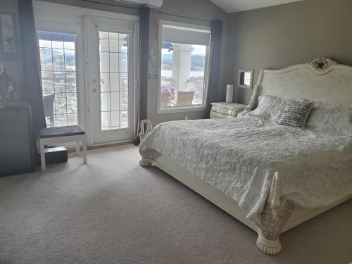 基洛纳Vacation Lake View House kelowna BNB的一间卧室配有一张床、一把椅子和窗户。
