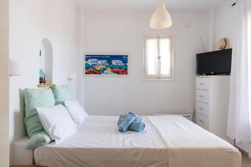 帕罗斯岛Cycladic home in Paros的一间白色卧室,配有床和电视