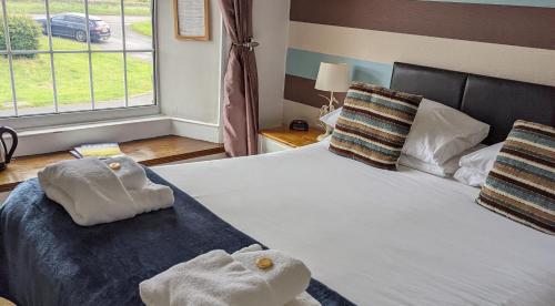 Shotley BridgeThe Manor House Inn的一间卧室配有带毛巾的床