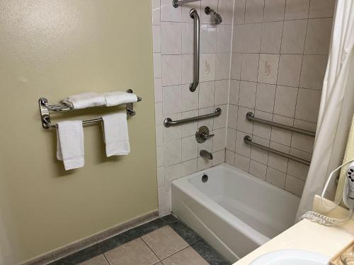 皮科里韦拉Rivera Inn & Suites Motel的浴室配有浴缸、淋浴和毛巾。
