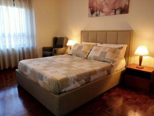 加亚新城Apartamento Alvares Cabral的一间卧室配有一张带椅子的床和一扇窗户