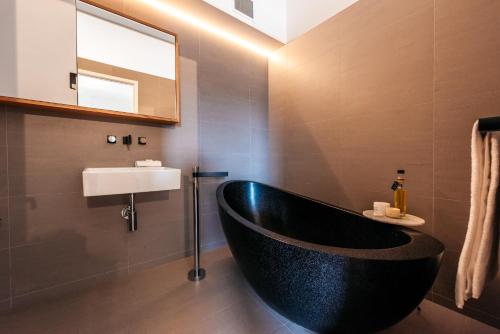黑潭Oneroa Beach Apartment的浴室配有黑色浴缸和水槽