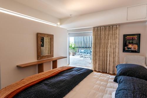 黑潭Oneroa Beach Apartment的一间卧室配有一张床,享有庭院的景色