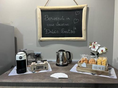 夸尔图-圣埃莱娜Casa vacanze “Dolce sosta”的一张桌子,上面有糕点,还有一个带标志的粉笔板