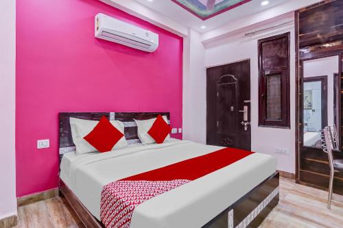 加济阿巴德Super OYO The Prima Residency的卧室设有粉红色的墙壁和一张床