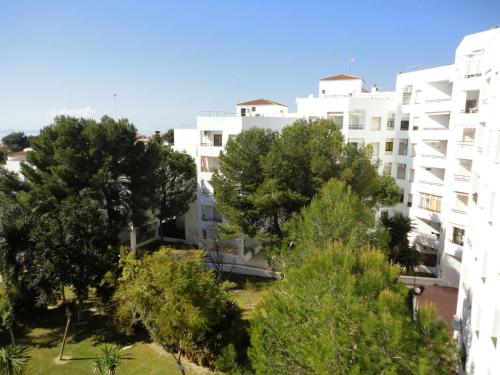 圣玛丽亚港Apartamento El Ancla - cerca la playa的公寓大楼前面有树木