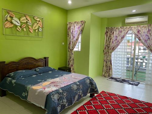 太平Makmur homestay的一间卧室设有绿色的墙壁、一张床和窗户
