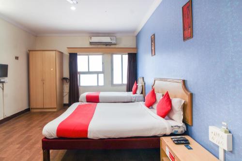 AmeerpetOYO Luxury Villas Near Begumpet Airport的一间卧室配有两张带红白色枕头的床