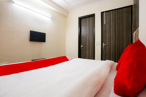 新德里OYO Royal Galaxy的卧室配有带红色枕头的大型白色床