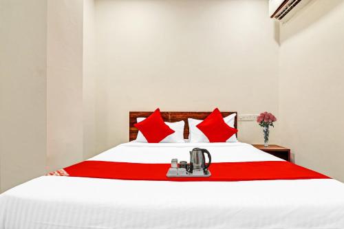 海得拉巴OYO Hotel Night Eye的卧室配有带红色枕头的白色床