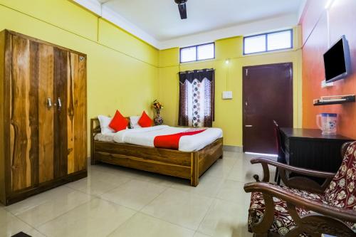 BhutiāgāonOYO Alohi Ghar的一间卧室配有一张床、一张桌子和一把椅子
