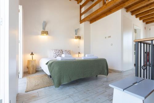 奥比多斯Mood Lodging - Óbidos的白色卧室配有一张带绿毯的床