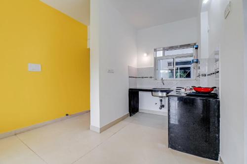多纳保拉OYO Home Hotel Sea Prince Suites的厨房设有柜台和黄色的墙壁