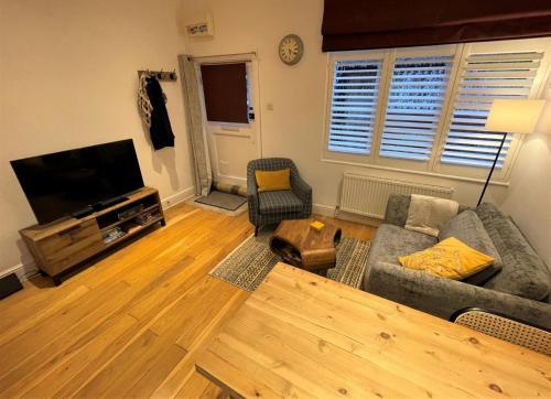 霍舍姆Peaceful Cottage for Two in Horsham的带沙发和平面电视的客厅