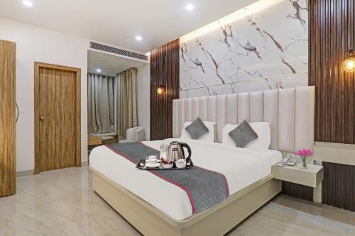 ChinhatSuper Townhouse 1149 Hotel Impact的卧室配有一张白色大床,上面有托盘