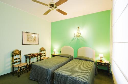 贝加莫齐塔德米雷酒店的一间卧室配有两张床和吊扇