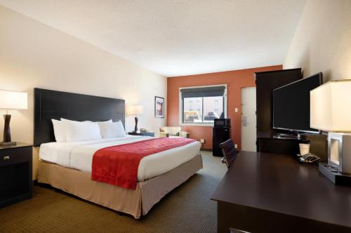吉列Red Lion Hotel Gillette的酒店客房设有一张大床和一张书桌。