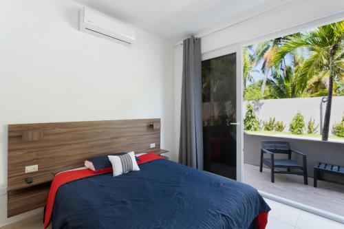 El ZapoteBeach front Blue Summer Apartment Costa Del Sol的一间卧室设有蓝色的床和大窗户