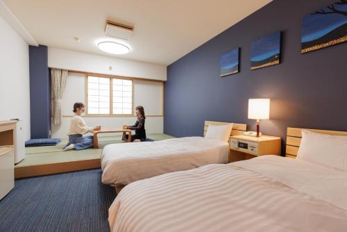 芦别芦别温泉星光大酒店的两人坐在酒店带两张床的房间