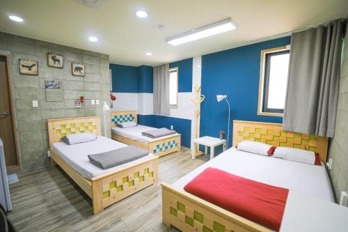 大邱大邱中城旅舍的一间卧室设有两张床和蓝色的墙壁