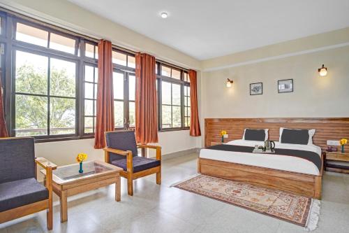 甘托克Capital O Bhumpadzong Retreat的一间卧室配有一张床、两把椅子和一张桌子