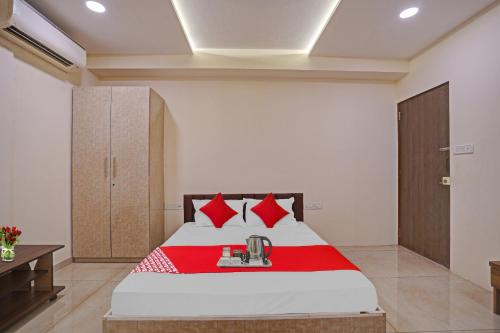 苏拉特Flagship Hotel Paradise的一间卧室配有红色枕头的床