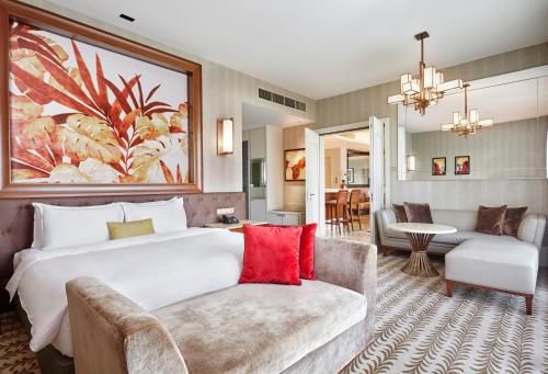 新加坡Resorts World Sentosa - Equarius Hotel的酒店客房设有一张大床和一张沙发。
