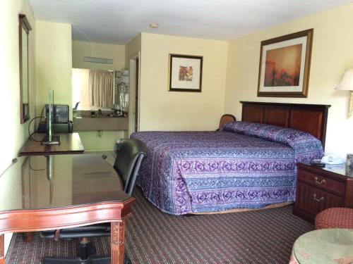 奥古斯塔Knights Inn Augusta Fort Gordon的配有一张床和一张书桌的酒店客房
