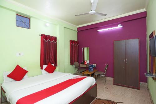 布巴内什瓦尔OYO Near Kalinga Hospital的一间卧室设有一张大床,拥有红色和绿色的墙壁