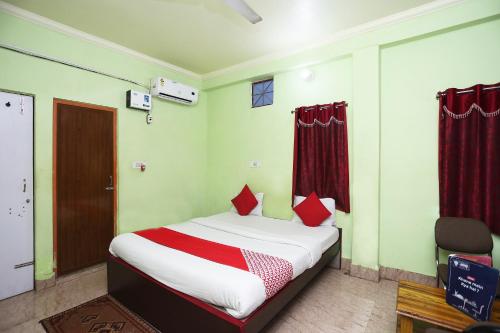 布巴内什瓦尔OYO Near Kalinga Hospital的一间卧室配有一张带红色枕头的床