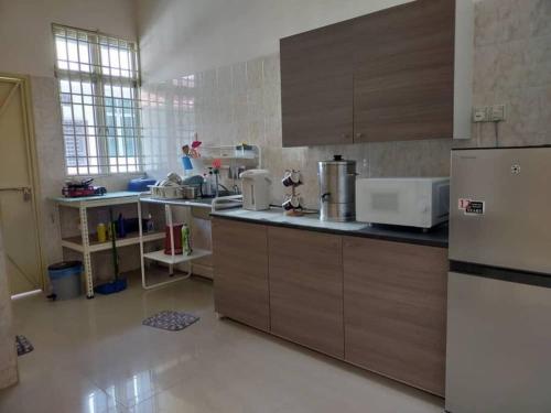巴特沃思Cheerful 3-Bedroom Residential Home with Free WIFI的厨房配有木制橱柜和冰箱。