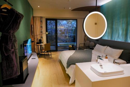 北京北京在之禾度假酒店的一间卧室配有床、水槽和镜子