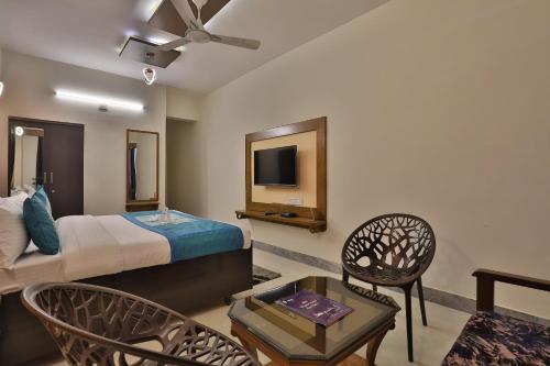 甘地讷格尔Super OYO Hotel Siddharth Inn的一间酒店客房,配有一张床和一台电视