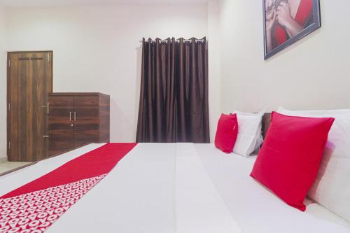 卢迪亚纳OYO Hotel Bella Ciao的卧室配有带红色枕头的白色床