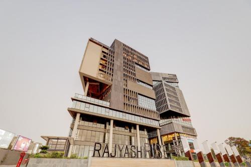 SarkhejTownhouse Rajyash Rise的一座高大的建筑,上面有标志