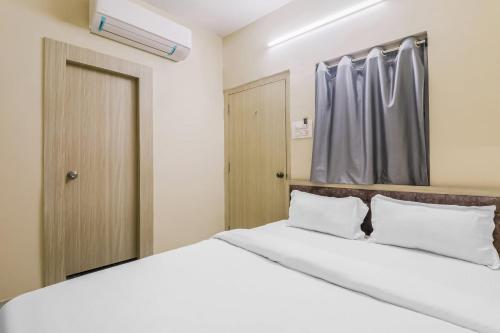 兰奇Super OYO Hotel Rameshwar的卧室配有白色的床和窗户。