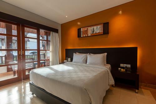 勒吉安十四玫瑰海滩酒店的一间卧室配有一张带橙色墙壁的大床