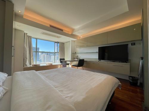 北京Beijing Elegant Seasons Park Apartment的一间卧室配有一张大床和一台平面电视