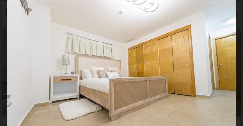 璜多里奥Marbella Juan dolio beach front luxury apartment的一间卧室配有一张床和一个木制衣柜