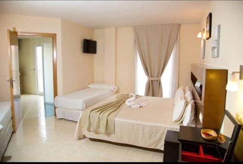 圣马丁德拉韦加Hostal San Marcos的酒店客房设有两张床和电视。