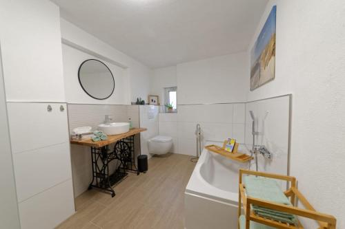 BeilingenCasa Eifel的带浴缸、盥洗盆和卫生间的浴室