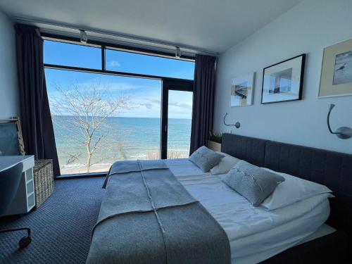 尤斯托尼莫斯基Apartment Morski Widok w Boulevard Ustronie Morskie的一间卧室设有一张床,享有海景