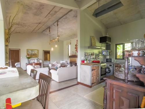 沙马雷勒Green Cottage Chamarel的厨房以及带桌椅的起居室。