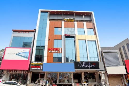 瓦朗加尔Super OYO Capital O Vihari Grand Inn的城市街道上一座拥有商店的建筑
