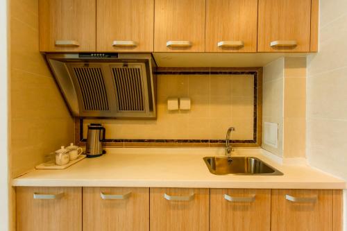大连大连红熙缘酒店式公寓万达广场店的厨房配有水槽和微波炉